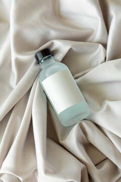 Transparent glass jar with lotion on fabric