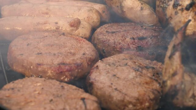 Beef burgers cooking on charcoal barbecue 