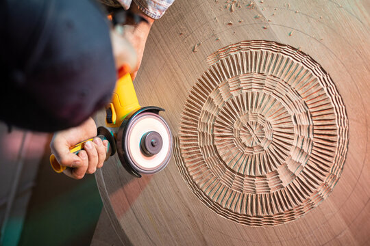 Artisan meticulously carve the hardwood to materialize his creation