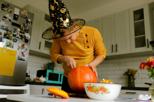 a man cuts a pumpkin for Halloween