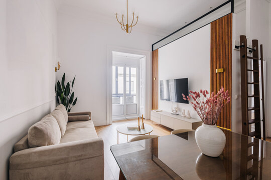 Modern living room with a beige sofa and a glass coffee table