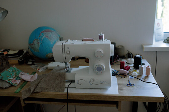 a woman sews on a sewing machine