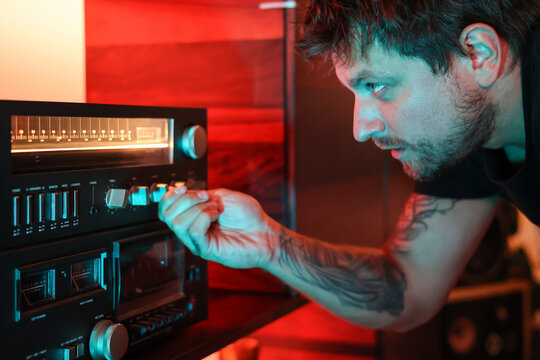 Portrait of dj selecting a radio frequency and looking attentive 