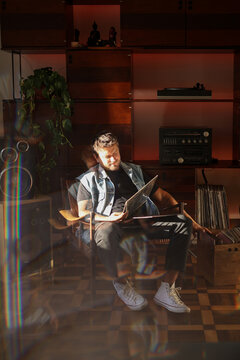 Musician reading the name of the songs in the back of a vinyl record