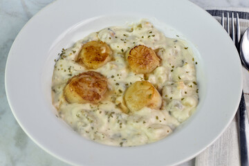 clam chowder top  with herbs and scallops