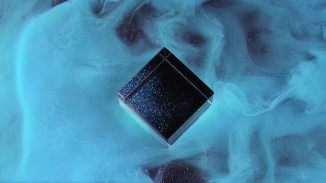 Magic fog. Ink flow. Abstract neon blue color mist cover black obsidian cube shape galactic shiny texture art water cloud background motion opener.