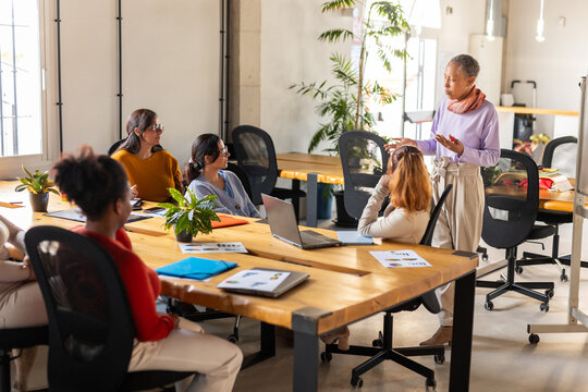 COMPANY OF WOMEN GETTING TOGETHER IN A COWORKING