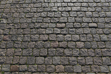Stone road background texture. Textured background of cobblestone road. Road from brick background. Paving stone and paved road. Sidewalk background.