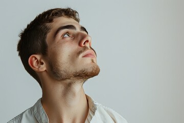 Obraz premium Thoughtful Man with Short Brown Hair and Stubble Looking Up