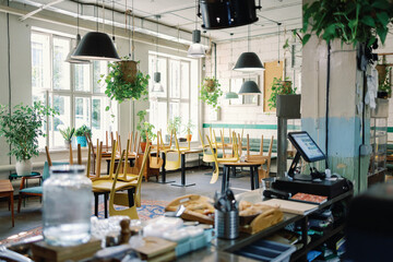 Interior of cafe with chairs over desks before opening at morning