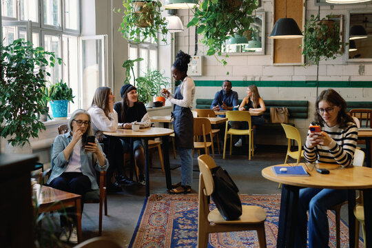 Multiethnic people resting and spending time in cafe at daytime