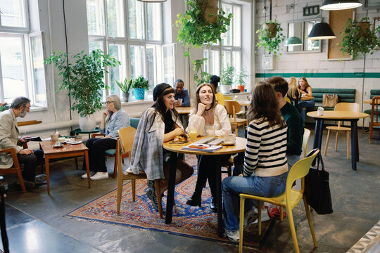Group of multiethnic people resting and spending time together in cafe