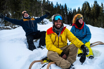 Three friends waiting to go sledging 