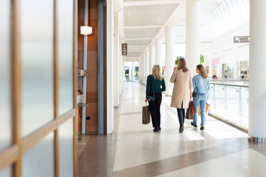 Back view of grandmother, mother and daughter looking away in mall