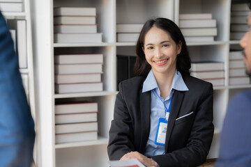 Confident Candidate's Warm Smile: A young professional radiates confidence during a job interview, engaging with potential employers in a modern office setting. 