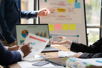 Strategic Collaboration: A diverse team of professionals engage in a collaborative discussion, analyzing data and charts, showcasing the intricate process of strategic planning. 