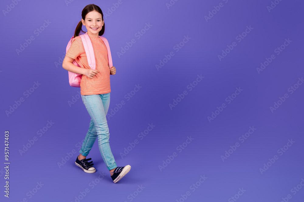 Wall mural full body photo of cute little girl backpack walking dressed stylish red clothes isolated on violet 