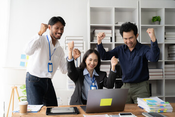 Office Triumph: A jubilant team celebrates success, their energy palpable as they gather around a laptop in a modern office.  