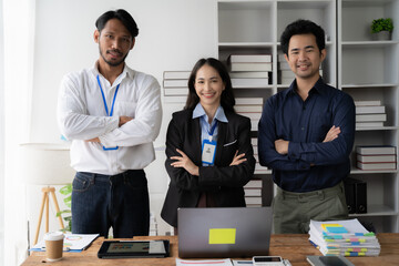 Confident and Ready: A diverse team of professionals stands united, arms crossed, exuding confidence and readiness in their modern office setting. The image captures a sense of strength, collaboration
