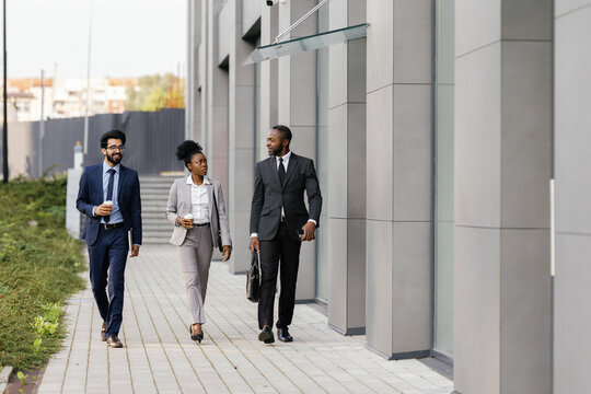 Office manager walking outdoors with her colleagues