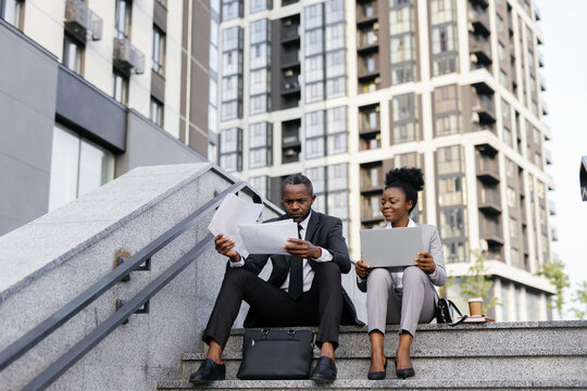 Manager looking through documents in presence of secretary outdoors