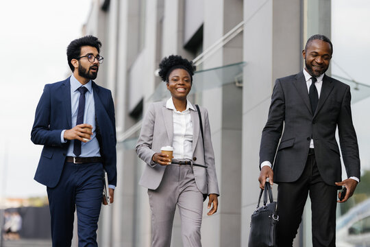 Employees strolling past office building during coffee break