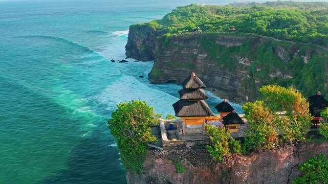 Bali's Most Iconic Landmark and popular tourist attraction Uluwatu Temple one of six key Bali temple perched on top mountain cliff on background amazing nature Bali, Indonesia. 4K Aerial view