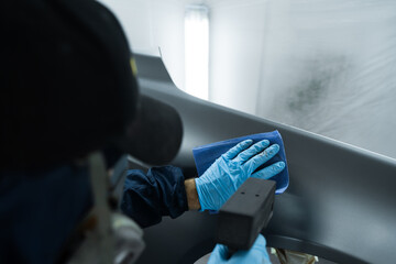 Car painter is working with anti static gun to prepare metal for paintwork. Using anti static gun...