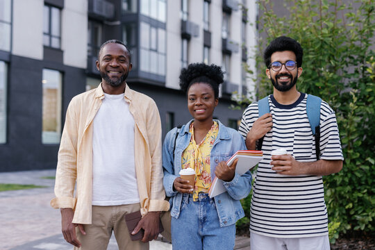 Coworkers posing for camera with boss during coffee break outdoors