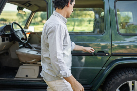 young man getting into his car to go on a trip
