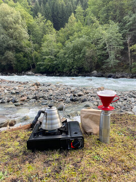 Making Coffee Near a River in the Mountains During the Day