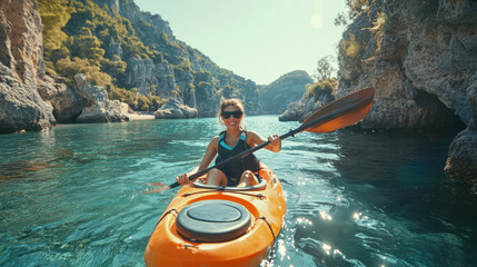 Fototapeta premium A kayaker exploring rocky valley in shallow sea