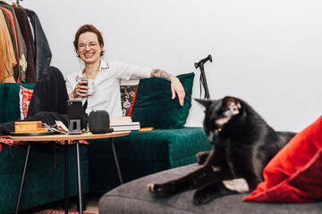 Happy Woman Having a Cup of Coffee and Laughing