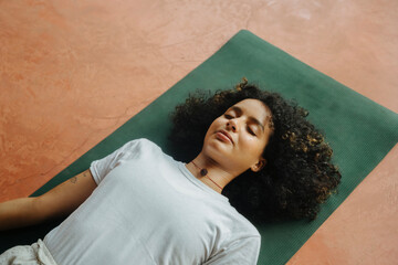 A woman lying down in Savasana pose