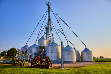 Grain Silos and Farming Equipment at Golden Hour, Eye-Level Perspective