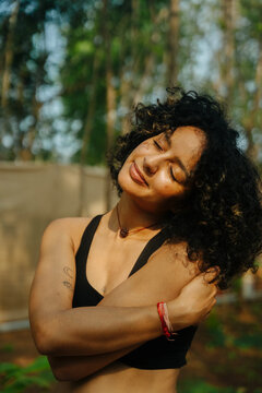 A woman hugging herself and head leaning to the left side
