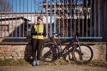 Obraz premium Woman Next to Bike Texting on Phone