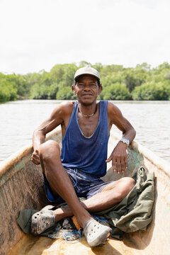 A native man sitting in a canoe at a river in the jungle