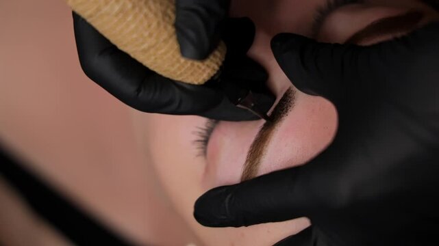 Close-up of a girl's eyebrow tattoo. Permanent eyebrow makeup, performing eyebrow tattoo PMU