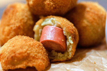 Close up crocket from potato with filling sausages. Side view.