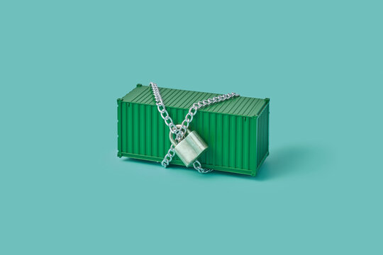 Green container for shipment crossed with chain and fixed with padlock