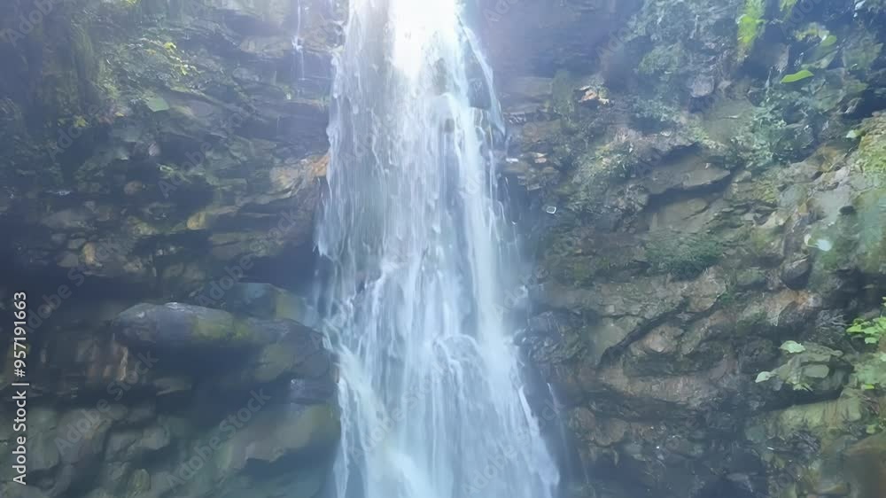 Poster Powerful waterfall cascades over mossy rocks in a lush, green forest, creating a magical and enchanting atmosphere