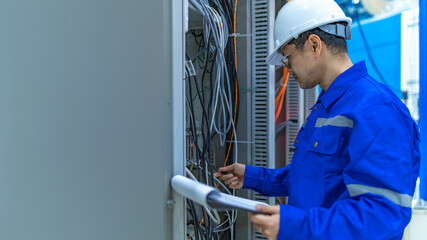 Electrical engineer woman checking voltage at the Power Distribution Cabinet in the control...