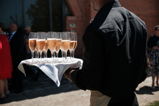 Anonymous waiter serving glasses of champagne 