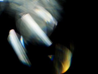 A blurry image of a light flare with a dark background. The image has a moody and mysterious feel...