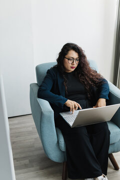 Woman seated using computer at work.