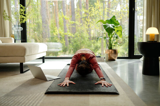 Woman Seated Yoga Pose with Laptop Nearby