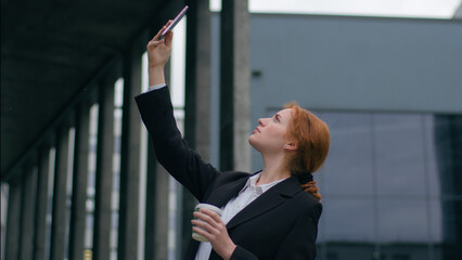 Worried young ginger Caucasian woman girl female student businesswoman suit rising hand mobile...