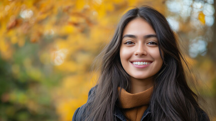 Fototapeta premium Copy space, stockphoto, Portrait of young happy smiling hispanic girl in autumn park, positive cheerful young woman enjoying a walk outdoors in autumn forest