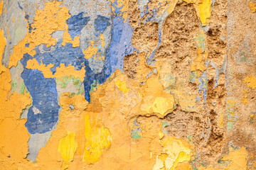 fondo de textura de una pared desconchada  y envejecida y con grietas en vivos colores en en colores amarillo y azules